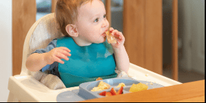 A toddler in a high chair eating yummy food, Clean Eating Spaces for Kids: High Chair Hygiene