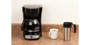 Coffee maker full of coffee with two mugs on the counter top, how to clean your coffee maker