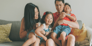 a family of 4 sitting on a couch cleaning