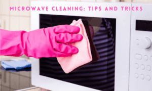 a hand with a pink glove cleaning the outside of a microwave